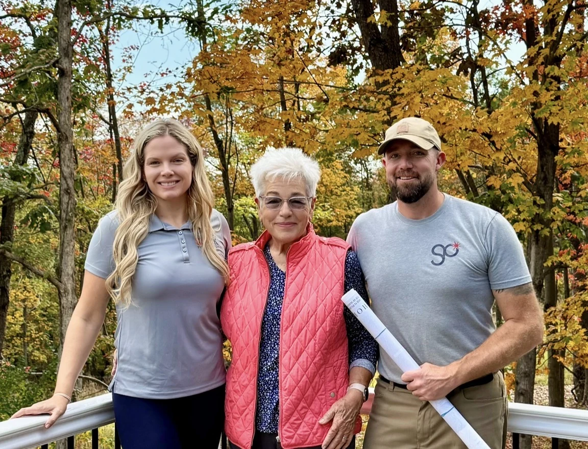 Margaret on the left, Jackie in the center, and Justin on the right, surrounded by autumn trees at Sky Mountain Retreat