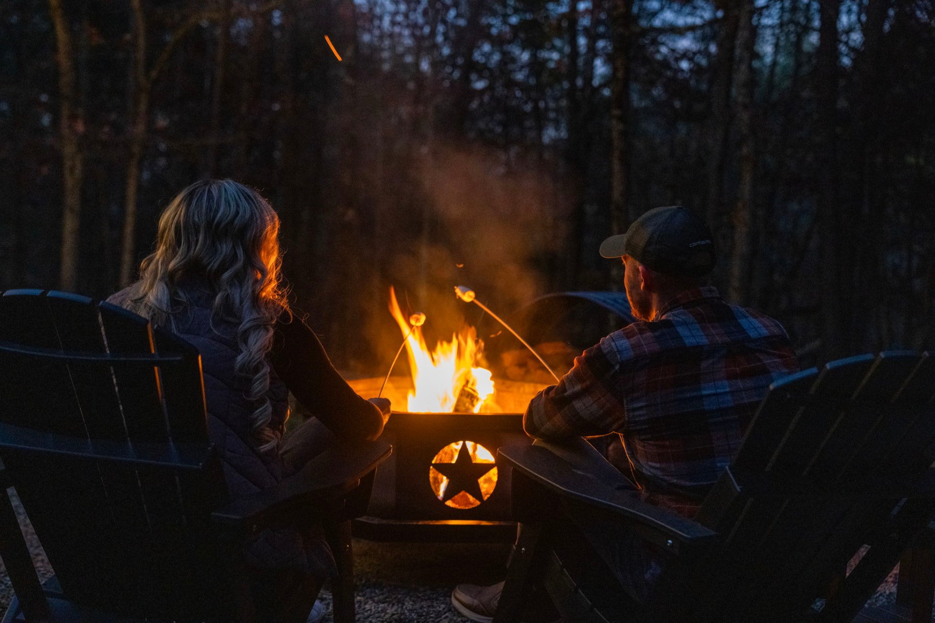 Couple roasting marshmallows around the fire at Sky Mountain Retreat
